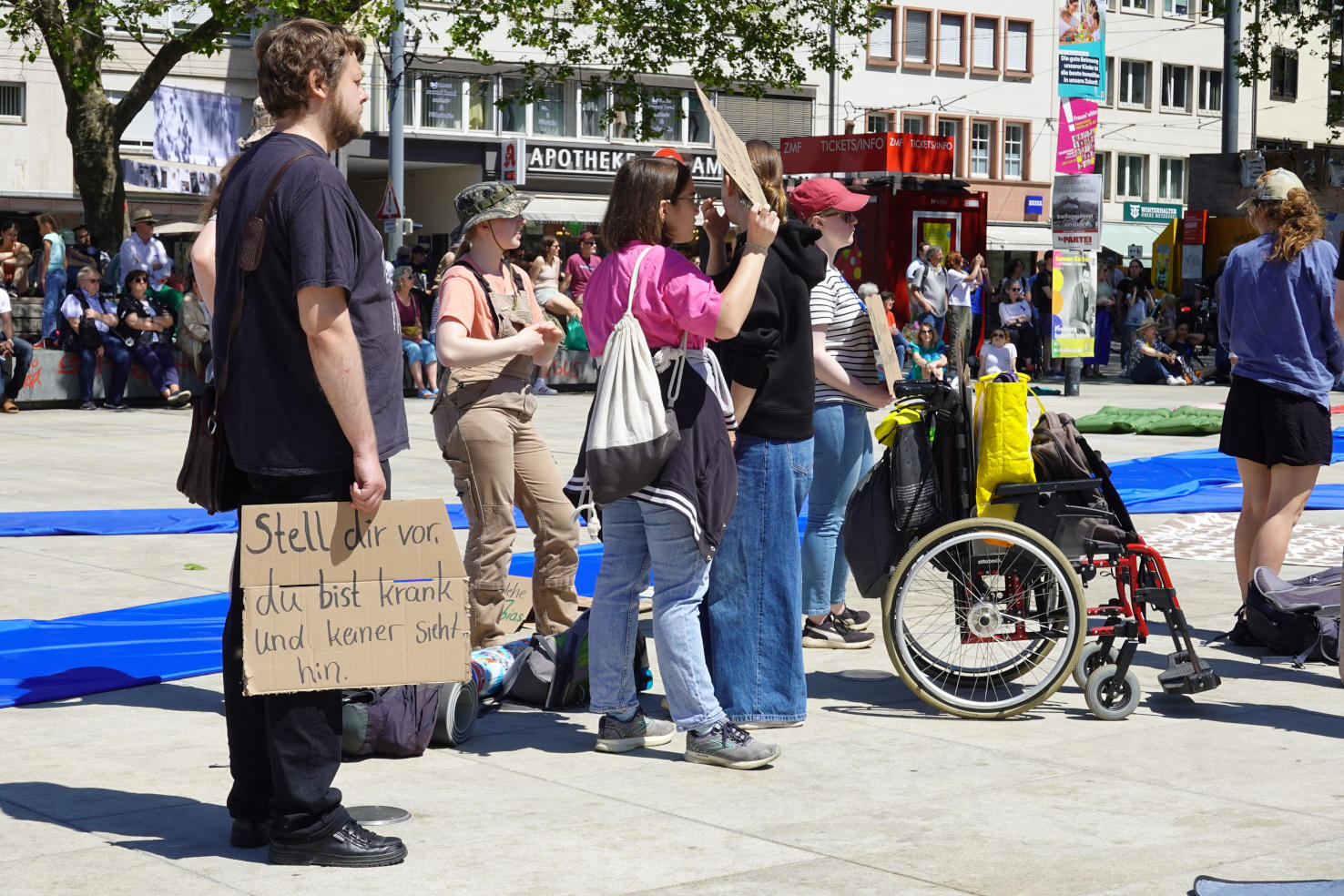 Bildbeschreibung: Foto von einer Gruppe Demonstrierender. Einer hält ein Schild mit der Aufschrift "Stell dir vor, du bist krank und keiner sieht hin"